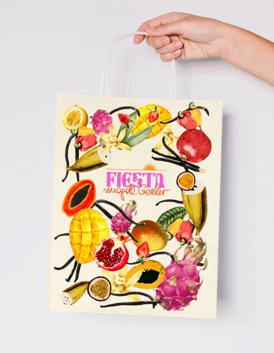 Hand holding a paper bag printed with the Fiesta fruit key visual